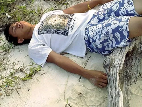 Tiduran di tepi pantai.