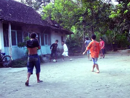 Bermain bola di pekarangan.