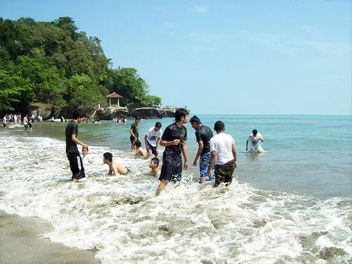 Bermain bersama ombak di Pantai Karang Bolong.