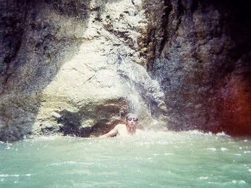 Berenang di bawah aliran air terjun.